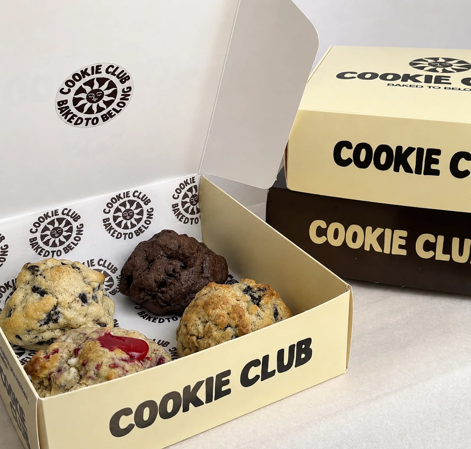 Caja artesanal Cookie Club abierta con 4 cookies a elegir: red velvet, doble chocolate y más sabores premium en Playa del Carmen